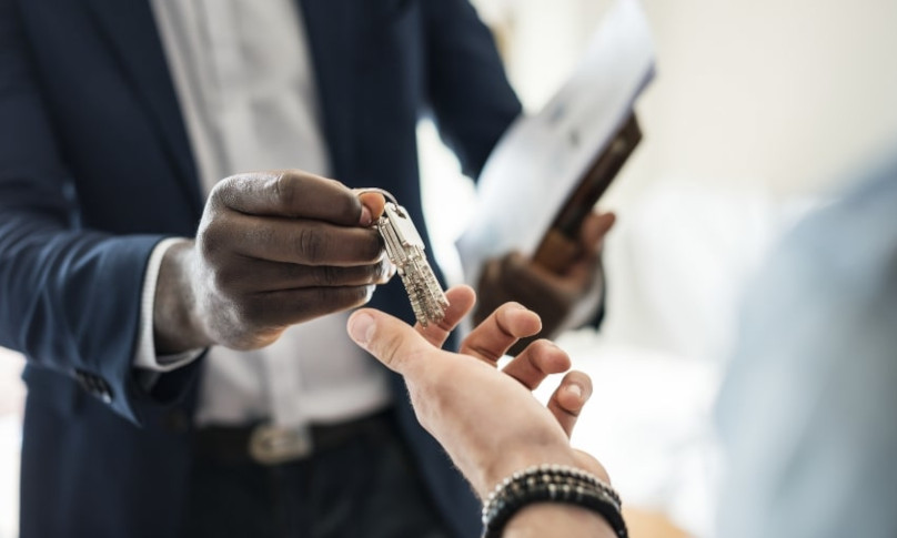 Real estate agent giving the key to the house to the new owners